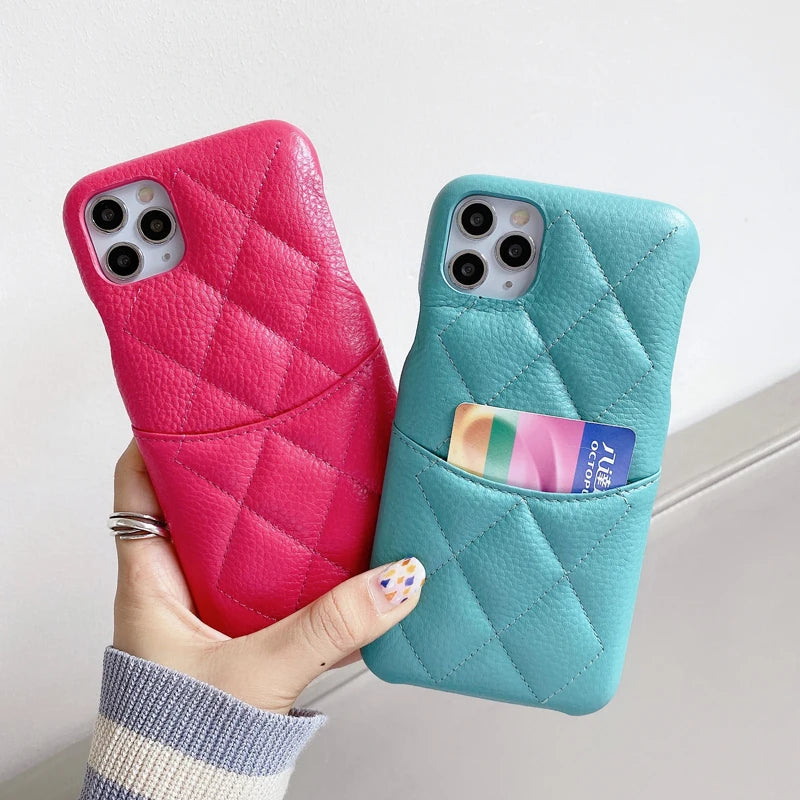 Two phone cases, one pink and one blue, held by a hand against a light background.
