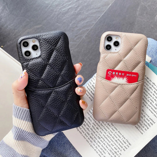 Two phone cases, one black and one beige with a card pocket, held over an open book.