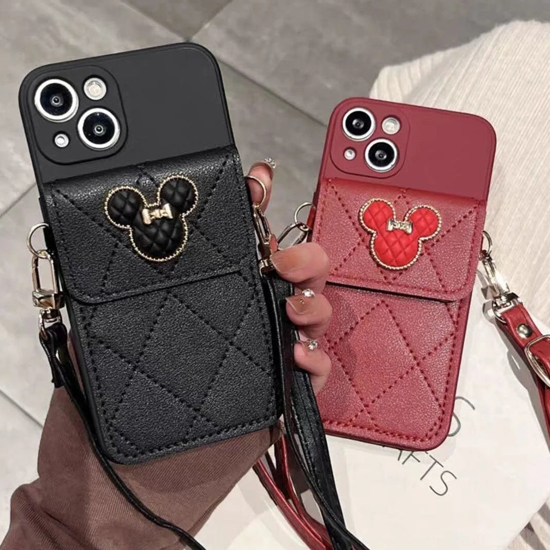 Black and red phone cases with Mickey Mouse designs held by a person.